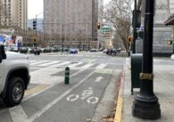 Intersection of Second and San Fernando with bike lane, enclosed by green bollards and parked cars