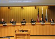 Một nhóm người đang ngồi trên bục tại một cuộc họp của chính phủ