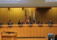 A group of people sitting at a dais at a government meeting