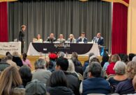 A crowd of people watch a political debate