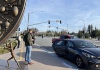 People wait for ride-share cars outside a public transit center