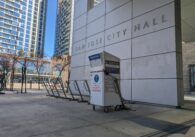 A ballot box in front of a wall with a sign that reads "San Jose City Hall"