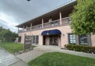 A building with a sign at the front reading "913 Willow Street" shown during a cloudy day.