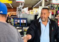 A business owner at the cash register is handing a customer cash back.