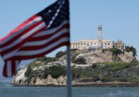 Alcatraz island outside of San Francisco, with an American flag in the foreground