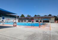 A pool divided into lanes with swimmers doing laps.