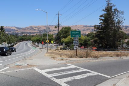 Photo of the highway 101 north entrance on Story road, with the highway and "Freeway entrance" signs visible and cars driving along Story Road in the background