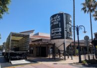 The outside of a restaurant with a moving truck and large water tower with words related to beer on it.