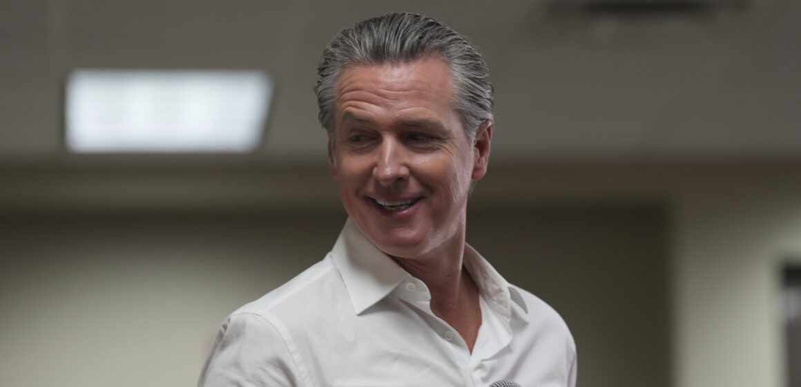 California Governor Gavin Newsom holding a microphone