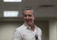 California Governor Gavin Newsom holding a microphone