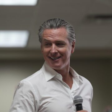 California Governor Gavin Newsom holding a microphone