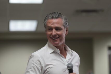 California Governor Gavin Newsom holding a microphone
