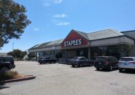 The outside of a Staples, with cars parked in front