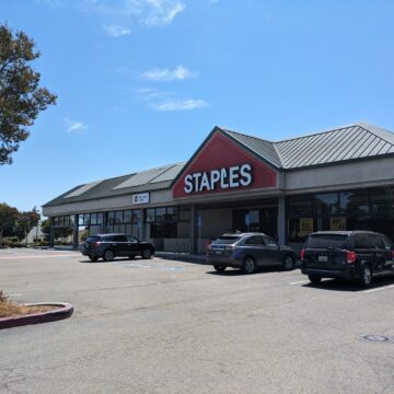 The outside of a Staples, with cars parked in front