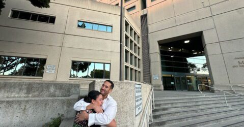 Un hombre y una mujer se abrazan afuera de la cárcel principal en San José, California.