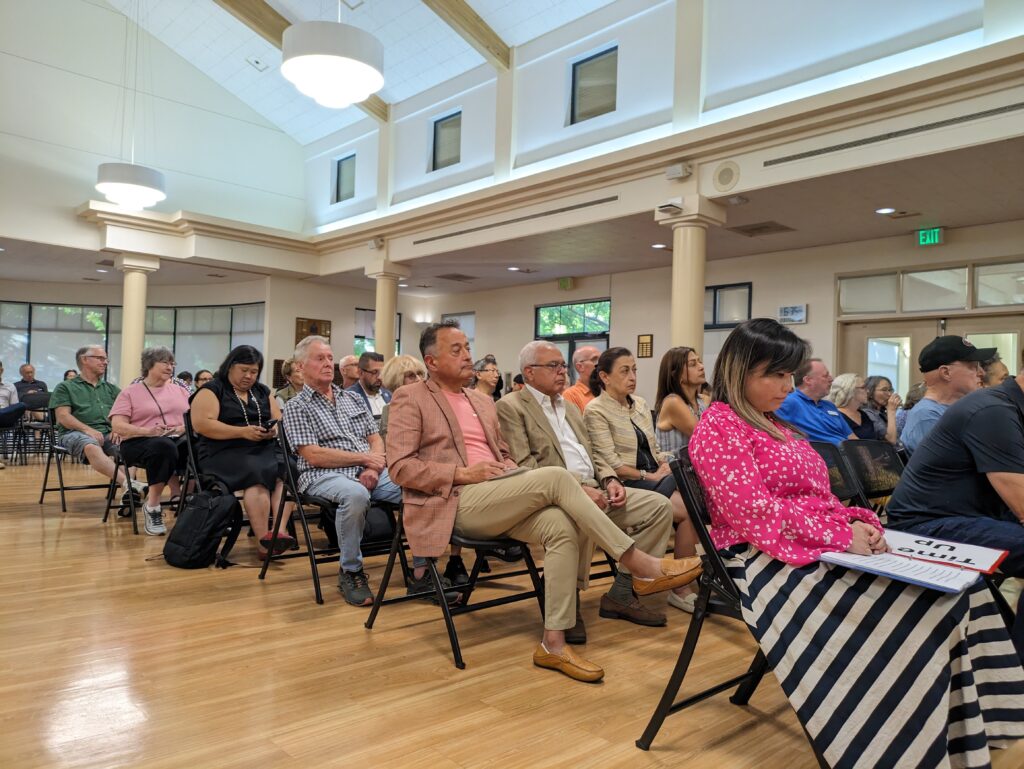 People sitting in chairs during a community meeting