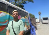 A man stands outside in front of a painted van