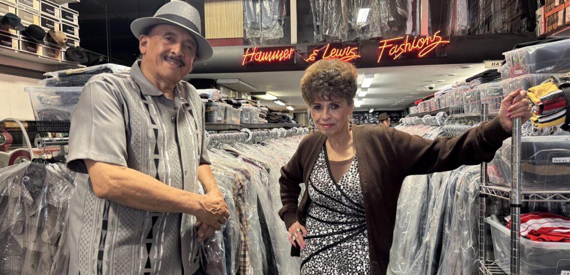 A man and woman standing in a clothing store