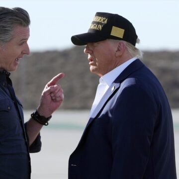 El gobernador de California, Gavin Newsom, habla con el presidente Donald Trump y la primera dama Melania Trump en el Aeropuerto Internacional de Los Ángeles.