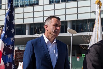 A man in a blue suit standing outside