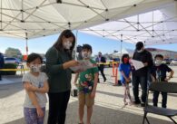 Two children and their mother standing in line to get COVID vaccinations in San Jose, California