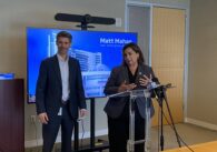 A man and woman stand at a podium