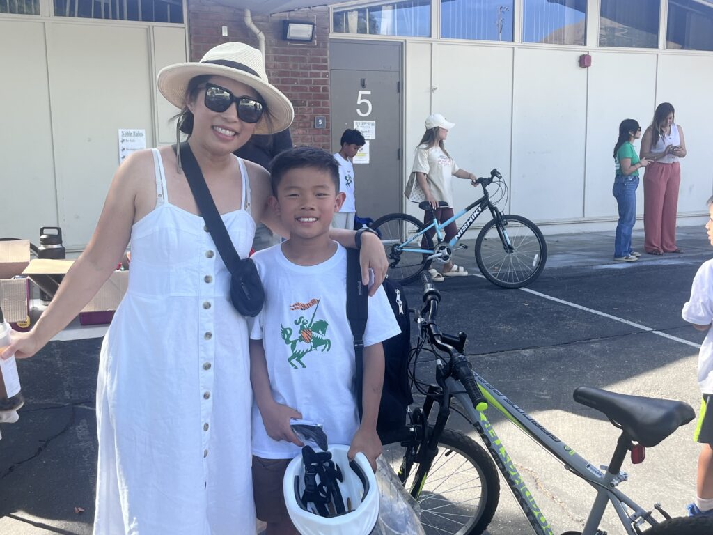 A mother and son pose for a picture with a donated bicycle