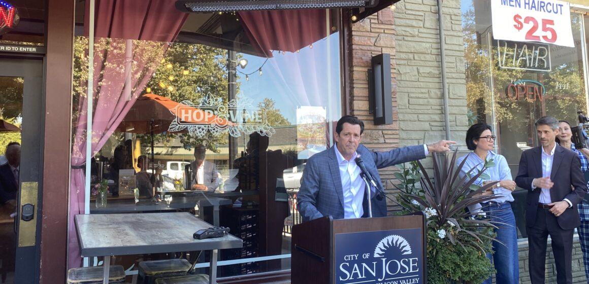A man speaking at a podium outside