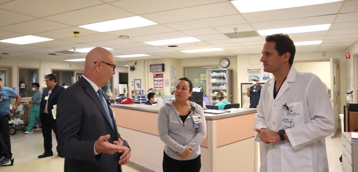 A man in a suit speaks to a female lead nurse and a male doctor in a hospital in San Jose, California