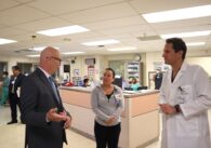A man in a suit speaks to a female lead nurse and a male doctor in a hospital in San Jose, California