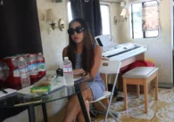 A woman wearing sunglasses sitting down at a table