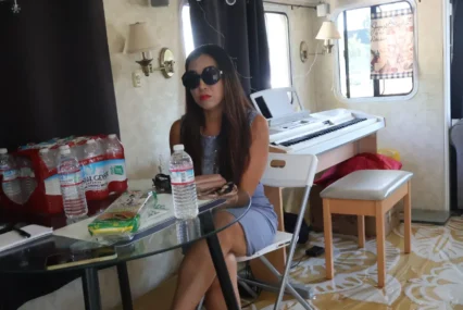 A woman wearing sunglasses sitting down at a table