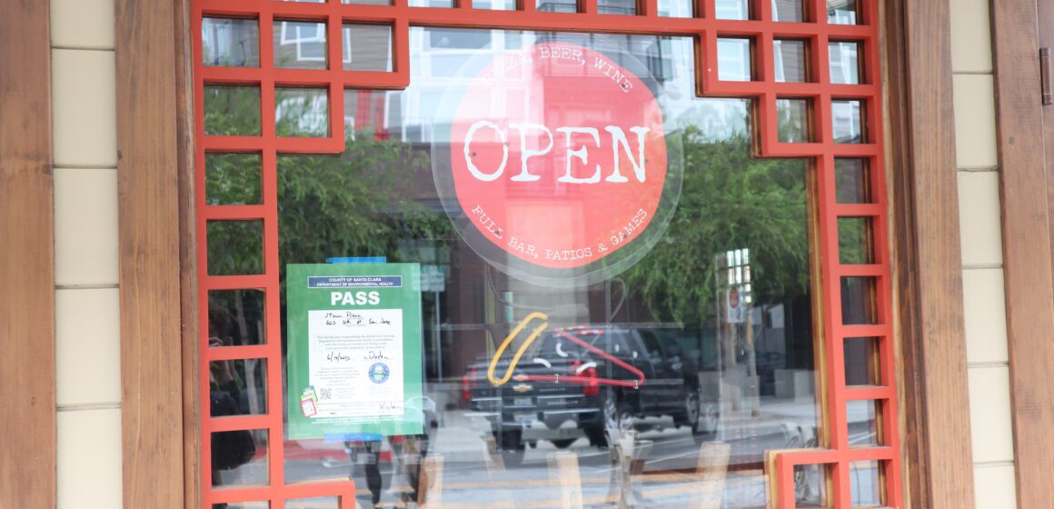 An open sign hanging in a restaurant window in San Jose, California