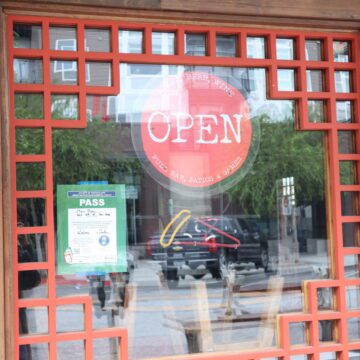 An open sign hanging in a restaurant window in San Jose, California