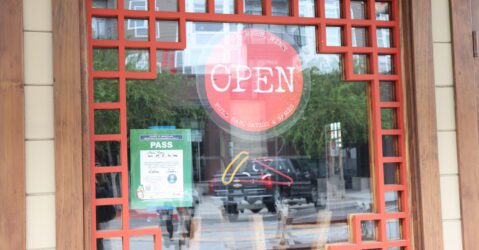 An open sign hanging in a restaurant window in San Jose, California