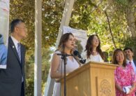 A woman speaks at a podium outside in San Jose, California