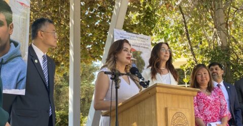 A woman speaks at a podium outside in San Jose, California
