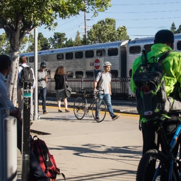 Palo Alto Caltrains People walking and waiting for a train at a station in Palo Alto, California