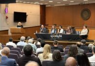 A seated audience looking at a panel of people behind a table