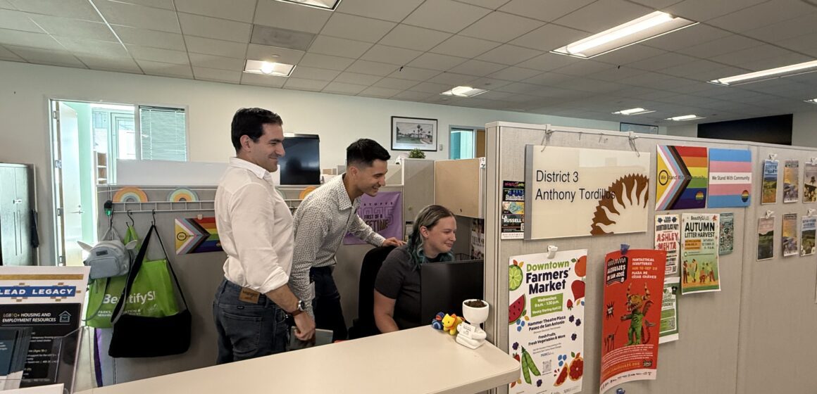 Tordillos D3 office team A group of people in a cubicle looking at a computer