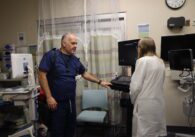 A man in scrubs speaks to a woman in a doctor's coat at a hospital in East San Jose, California
