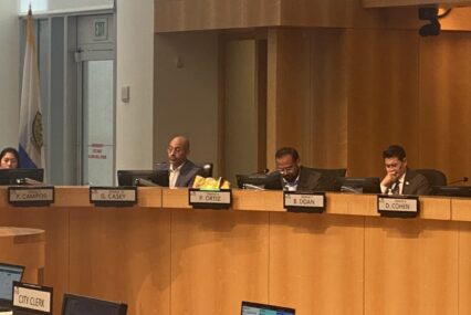 Four people sitting behind the dais at a government meeting in San Jose, California