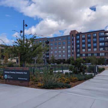 A seven-story apartment building behind a community park