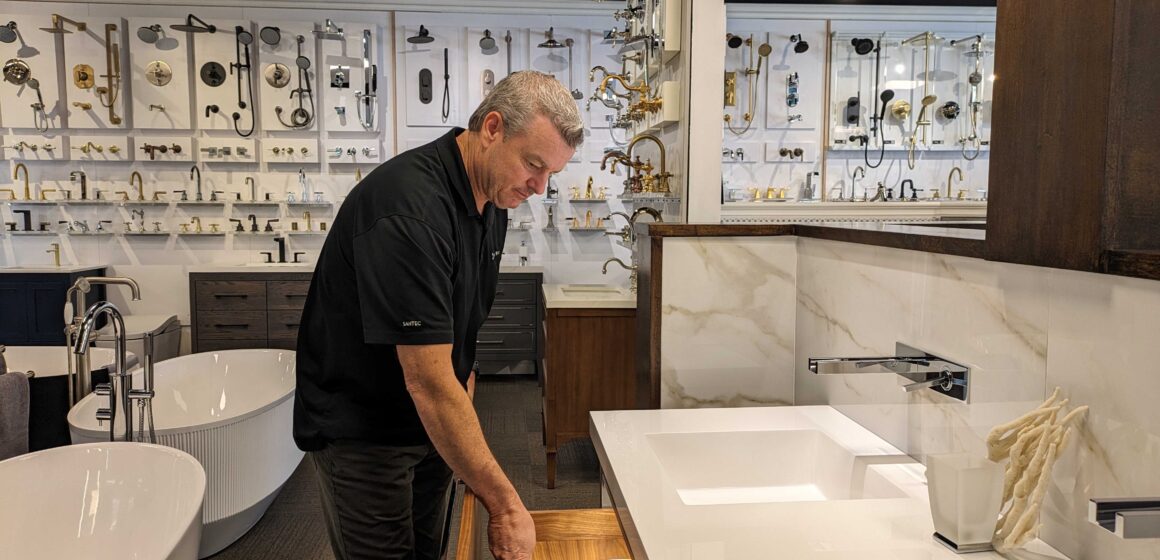 WILLOW GLEN - SPLASHWORKS OWNER ERIC NELSON A middle-aged man pulls open a drawer on a display bathroom sink