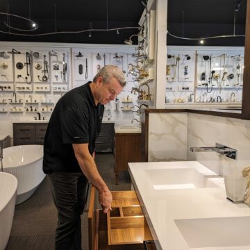 WILLOW GLEN - SPLASHWORKS OWNER ERIC NELSON A middle-aged man pulls open a drawer on a display bathroom sink