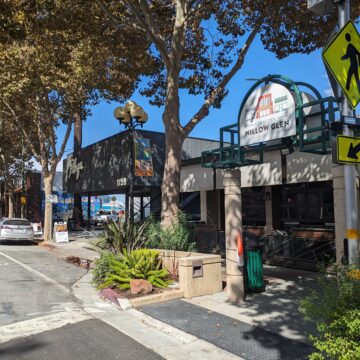 A view down a shady, small downtown street with a crosswalk and a sign that reads "Downtown Willow Glen"