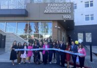 A group of people stand in a line behind a ribbon, with some holding large scissors, in San Jose, California