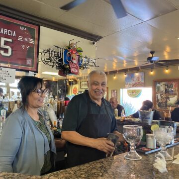 A man and a woman stand behind the counter at a restaurant in San Jose, California