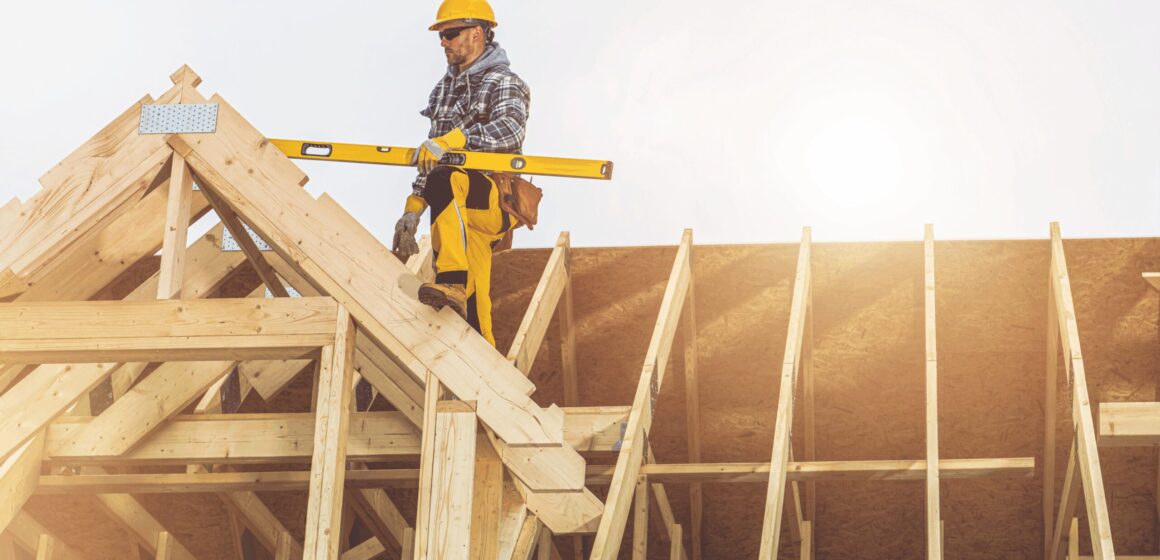 A construction worker on top of a house being built