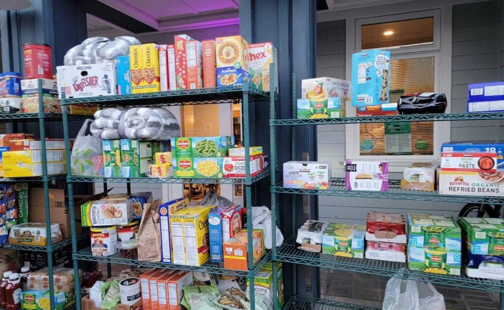 Groceries, ranging from Cheerios to canned green beans, line wire shelves